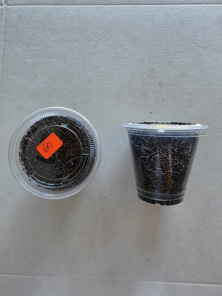 Chispas o granillo comestible de chocolate café oscuro en vaso