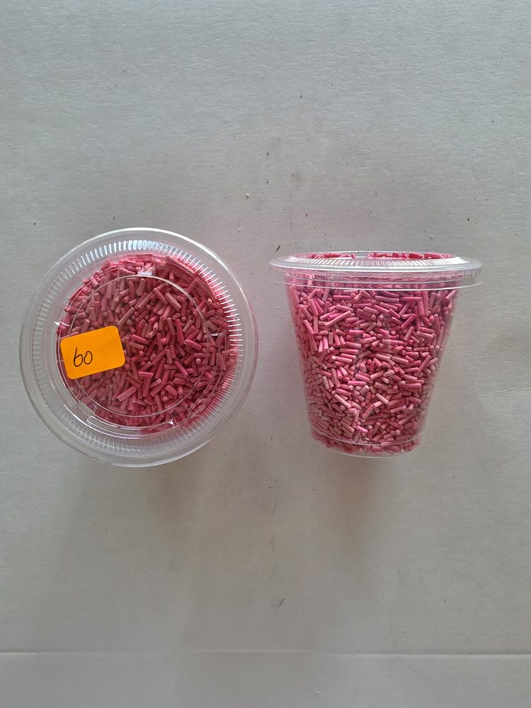 Chispas o granillo comestible rosado en vaso plástico transparente