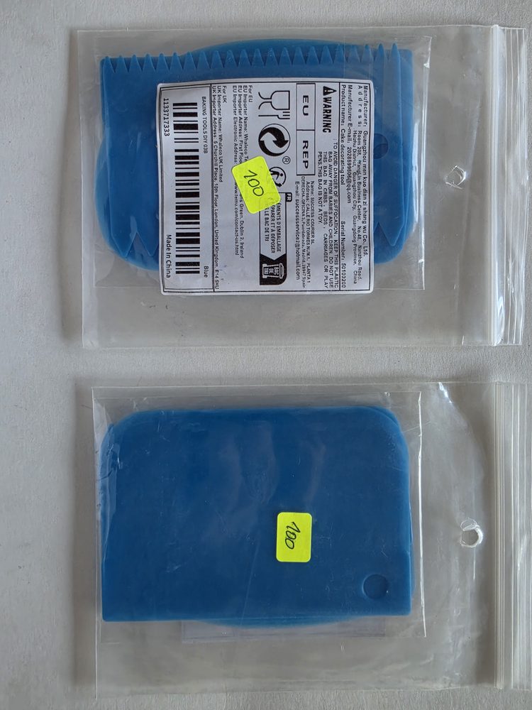 Dos raspadores de plástico azul en bolsas: uno con borde dentado