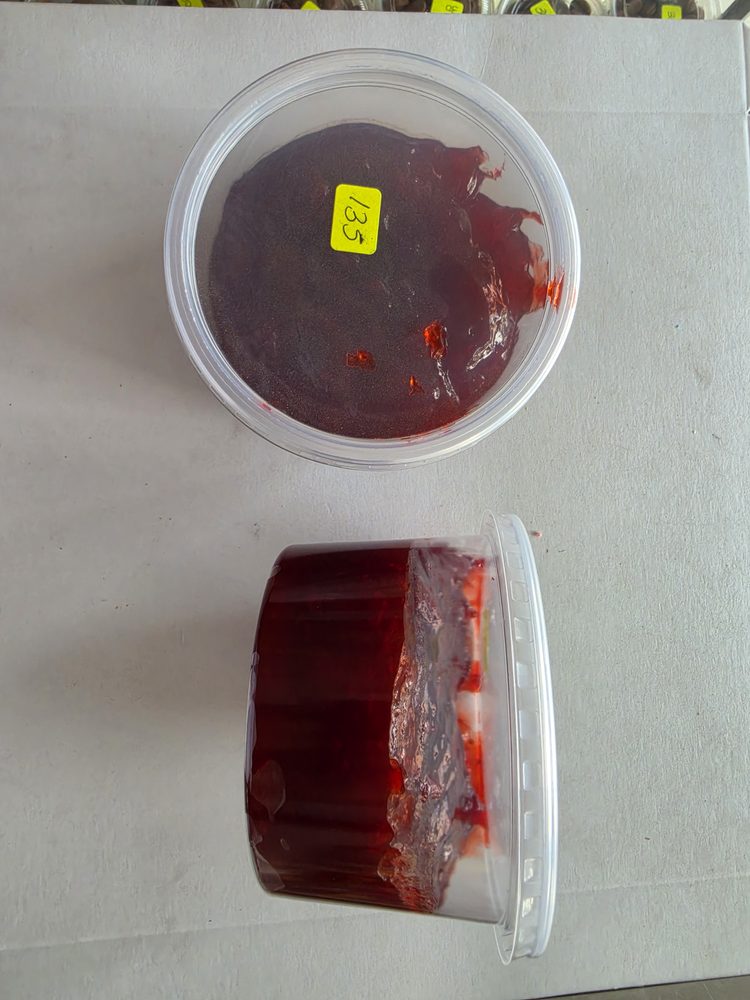 Jalea o mermelada de fruta roja color rojo vino, en envase plástico