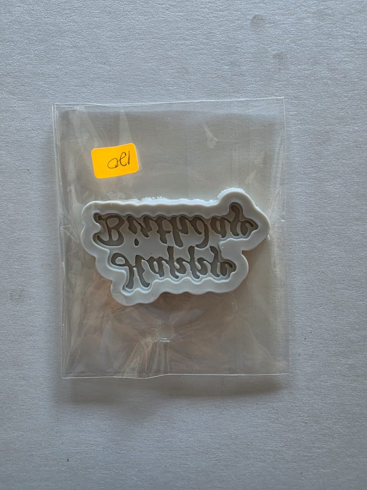 Molde de silicón blanco con el texto Happy Birthday en letra cursiva