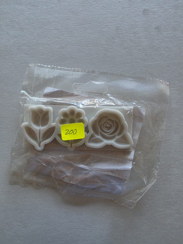Juego de tres moldes blancos con formas de tulipan, margarita y rosa