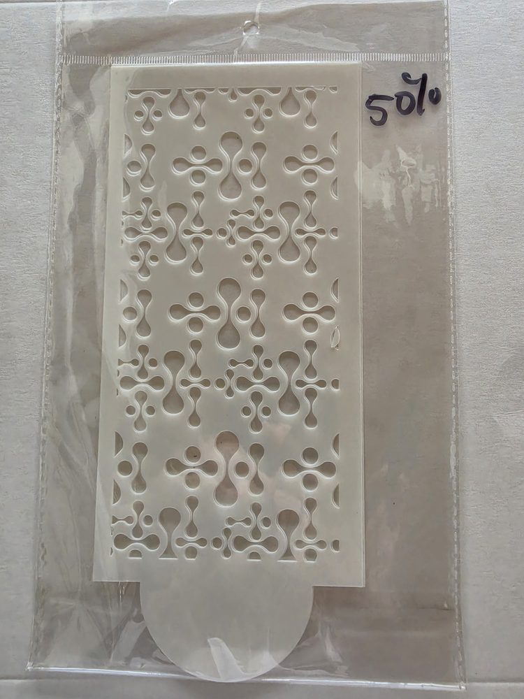 Esténcil de plástico blanco con patrón calado de gotas y círculos