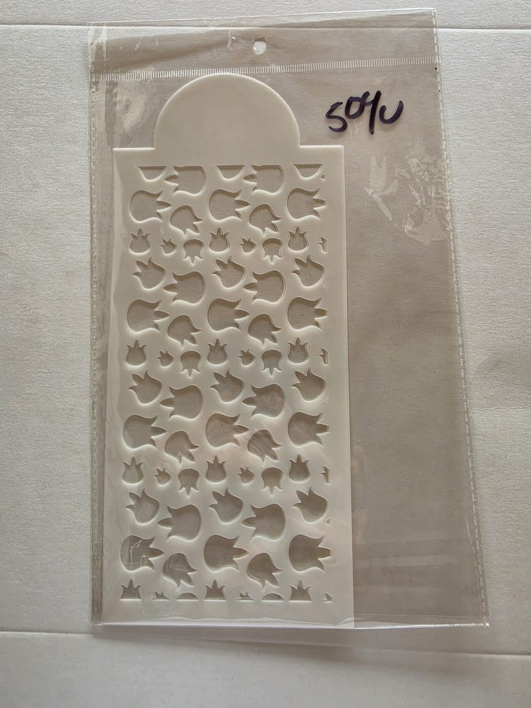 Esténcil de plástico blanco rectangular con figuras caladas